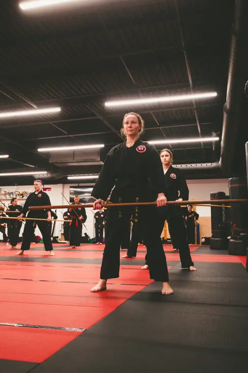 Deux instructrices présentent un bâton long devant la classe