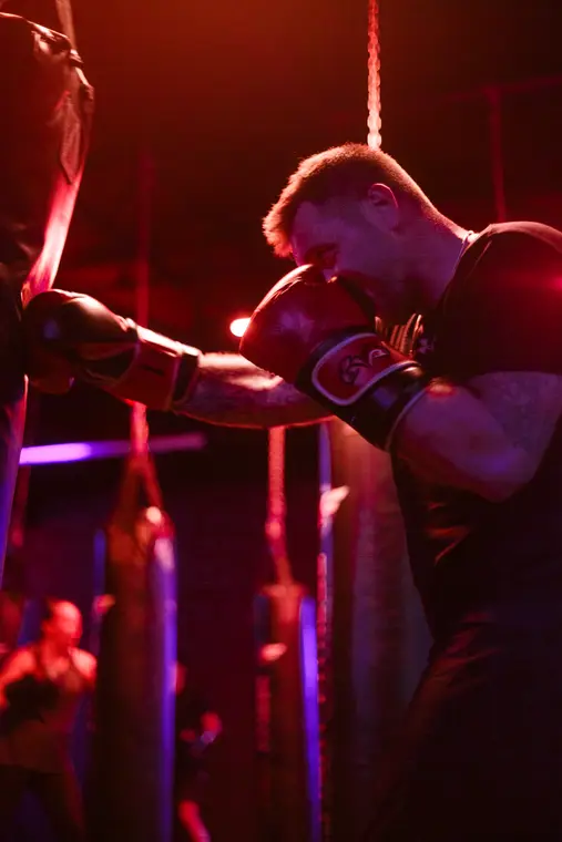 Gants de boxe entrechoqués dans une lumière rouge