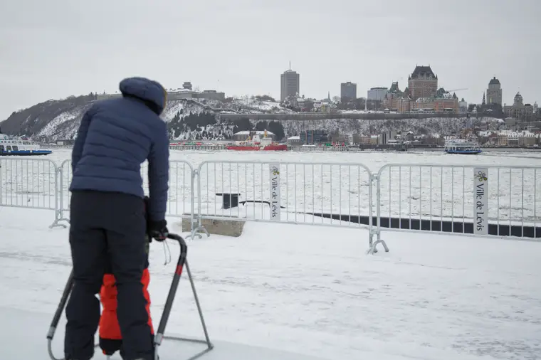 Promeneur face à la ville enneigée, de l’autre rive