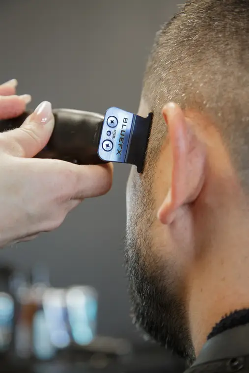 Tondeuse dégageant la nuque d’un client au salon
