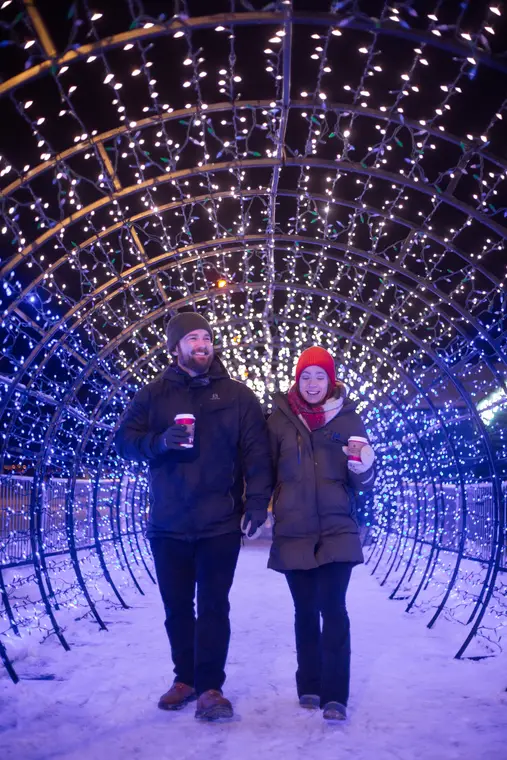Couple sous un tunnel de lumières d’hiver