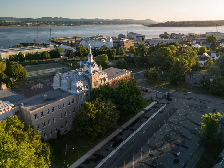 Grand bâtiment patrimonial au bord du fleuve, vu du ciel