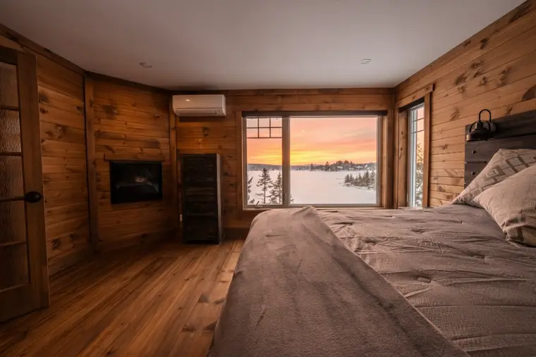 Chambre de chalet ouverte sur le lac au lever du jour