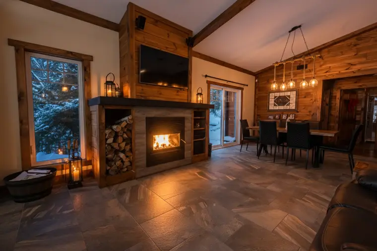 Salon de chalet avec foyer allumé