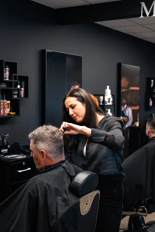 Coiffeuse au travail dans un salon de barbier