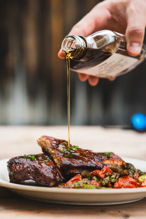 Sirop versé sur une pièce de viande braisée