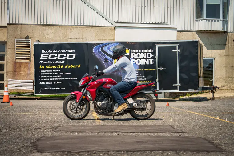 Motocycliste devant le local d’une école de conduite