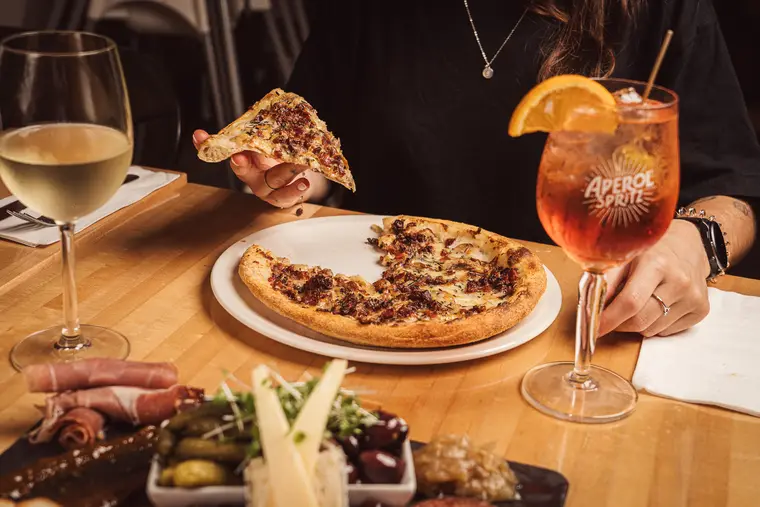 Pizza partagée et cocktails sur une table