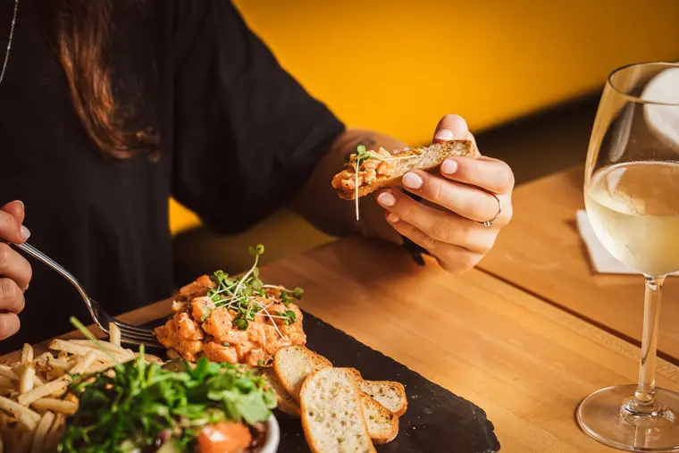 Repas au restaurant, mains et verre de vin