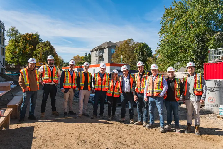 Équipe de chantier en dossards réunie devant un bâtiment