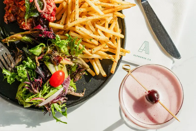 Salade et frites accompagnées d’un cocktail