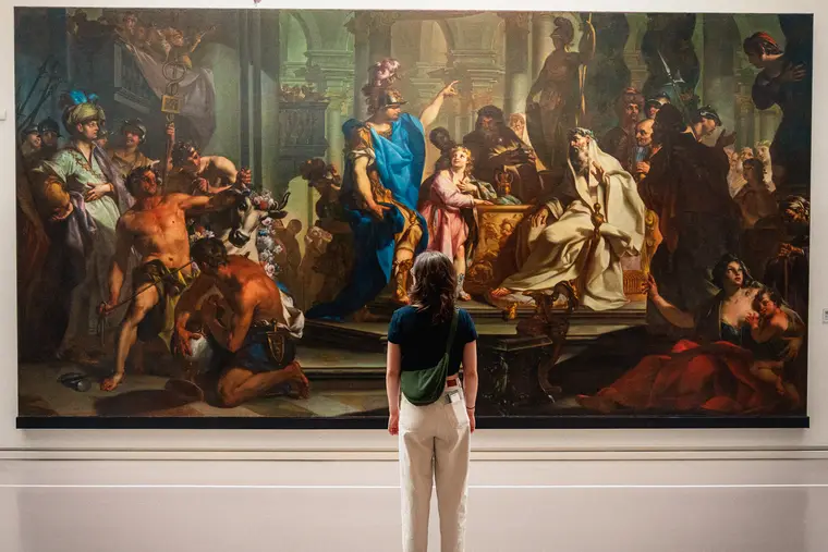 Visiteuse devant un grand tableau de musée
