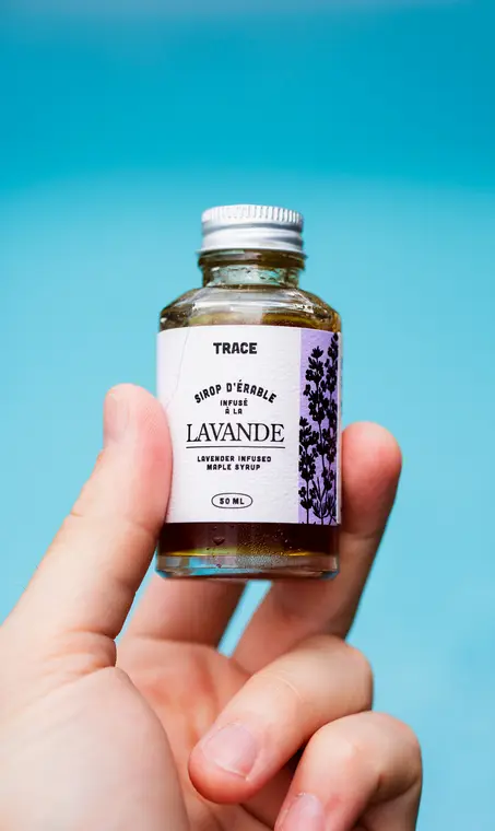 Fiole de sirop d’érable infusé à la lavande tenue à la main