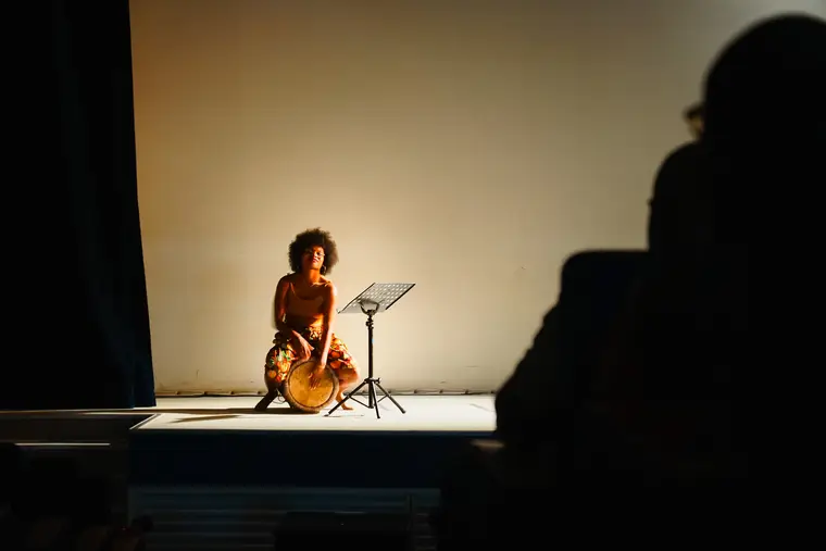 Artiste seule sur scène devant une salle