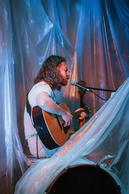 Guitariste chantant au micro sous les projecteurs